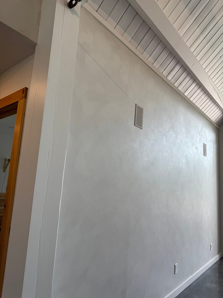 Soft white lime wash feature wall with cloudy movement under a vaulted ceiling, Ottawa