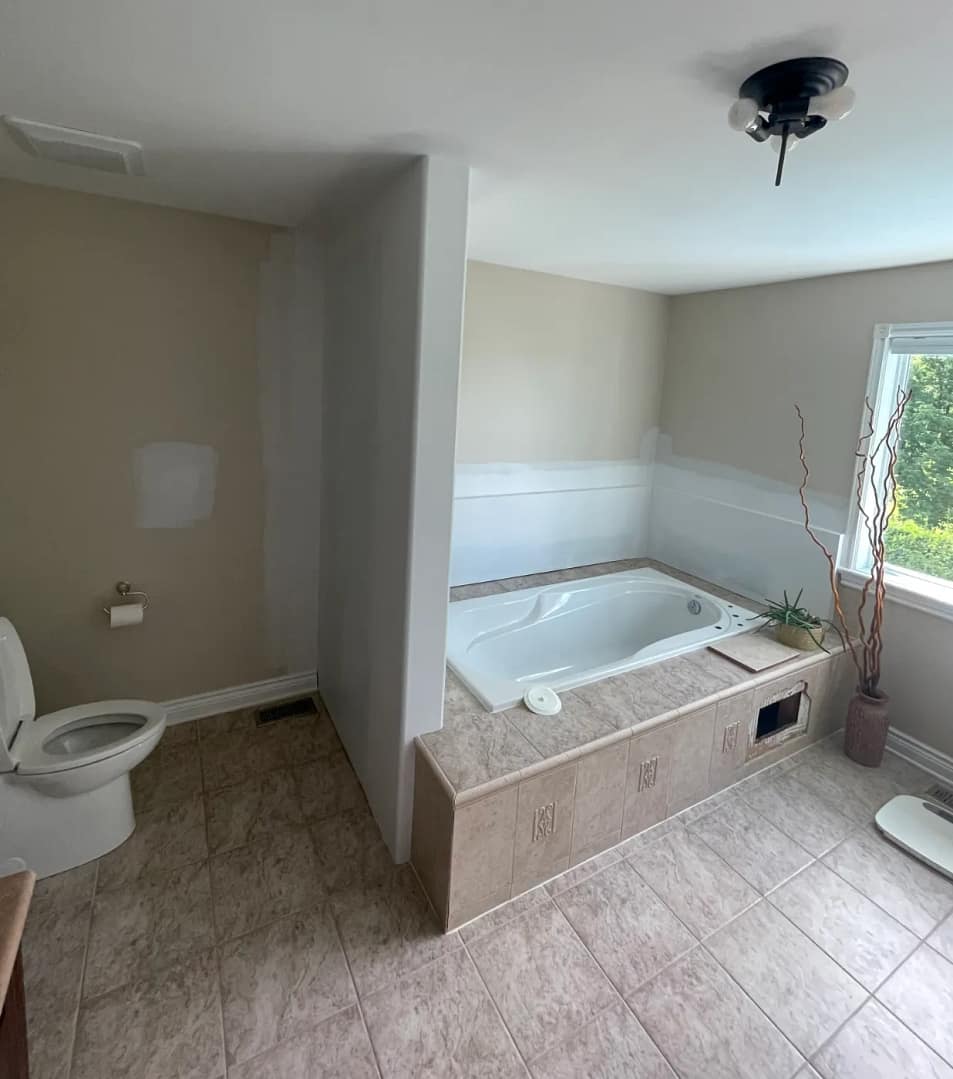 Dated beige tile tub deck and floor before being covered with microcement